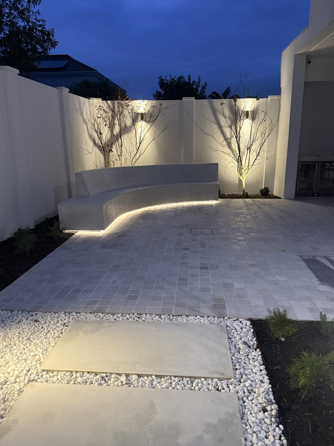 Curved bench with LED strip under-lighting in a courtyard
